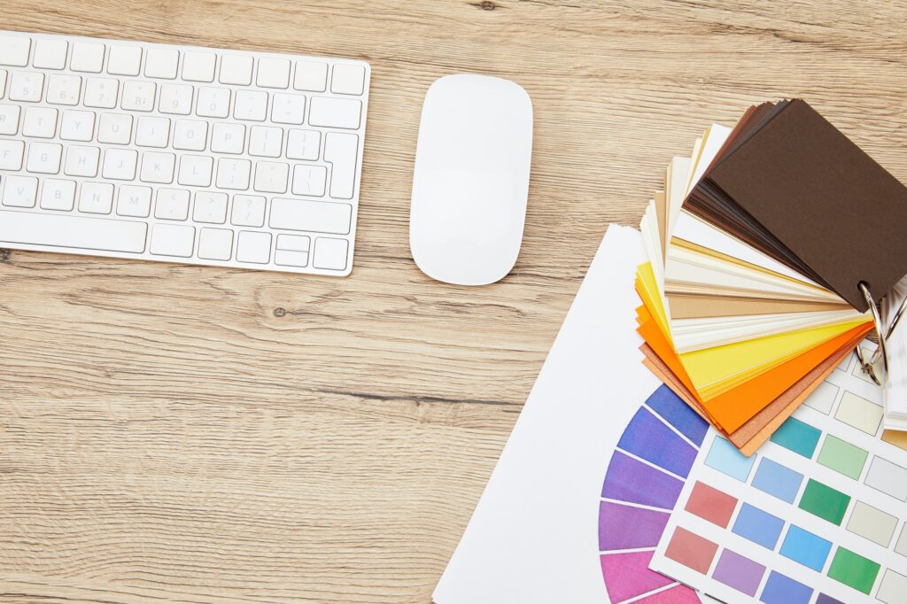flat lay with keyboard, computer mouse and colors pallet at designer workplace